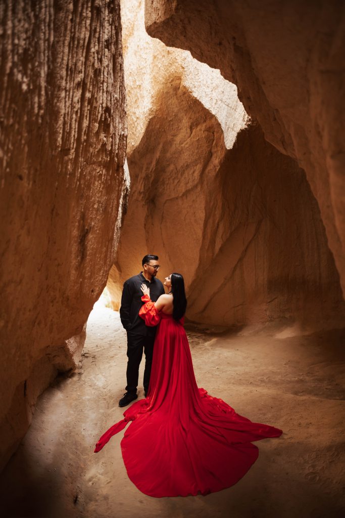 A couple inside a cave in Cappadocia, Turkey during sunrise for a photoshoot