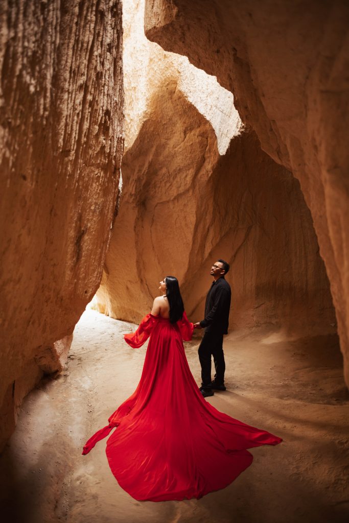 A couple inside a cave in Cappadocia, Turkey during sunrise for a photoshoot
