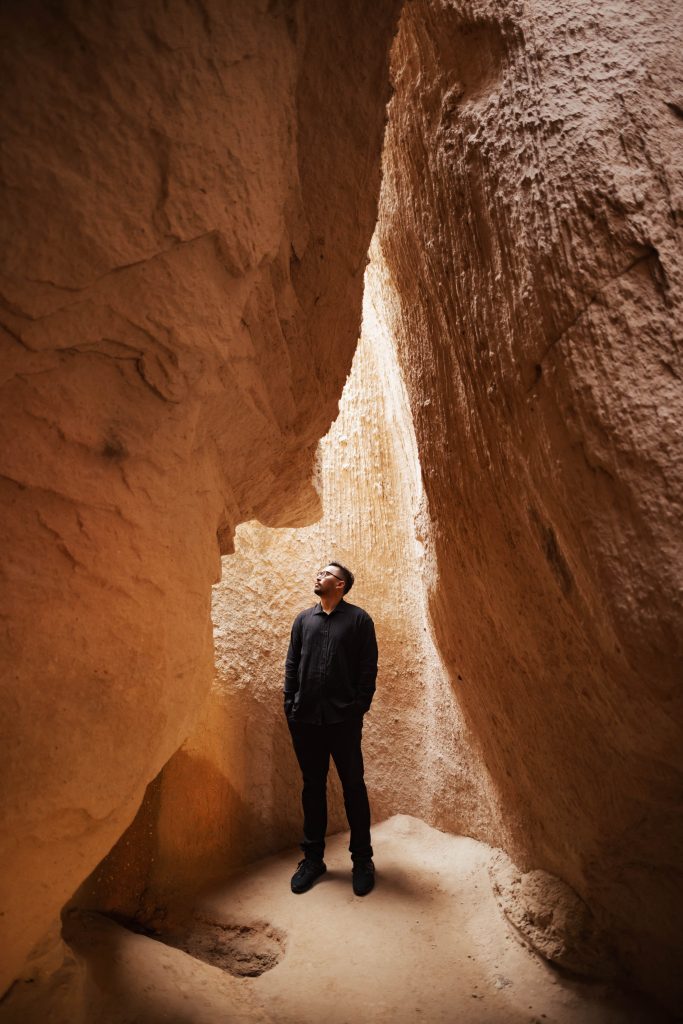 A man inside a cave in Cappadocia looking up during sunrise photoshoot
