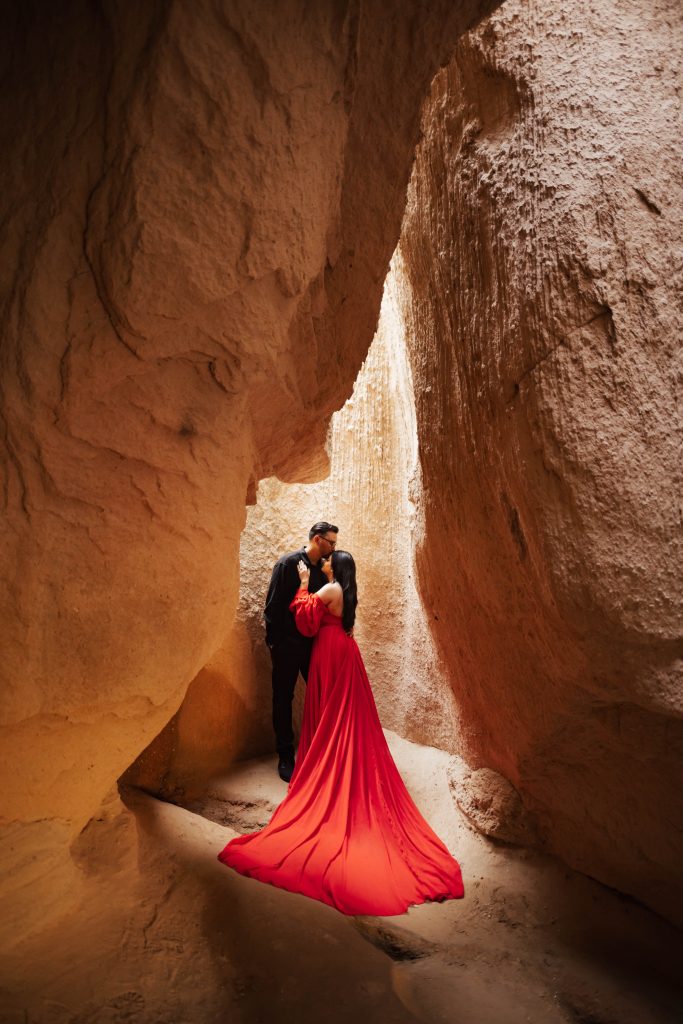 A couple inside a cave in Cappadocia, Turkey during sunrise for a photoshoot