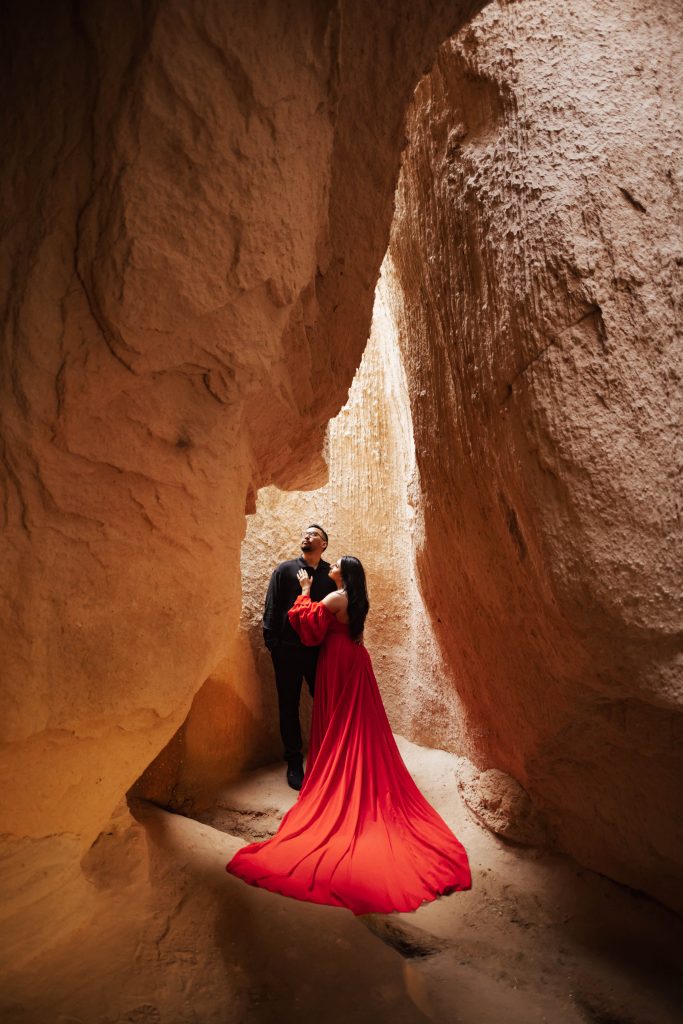 A couple inside a cave in Cappadocia, Turkey during sunrise for a photoshoot