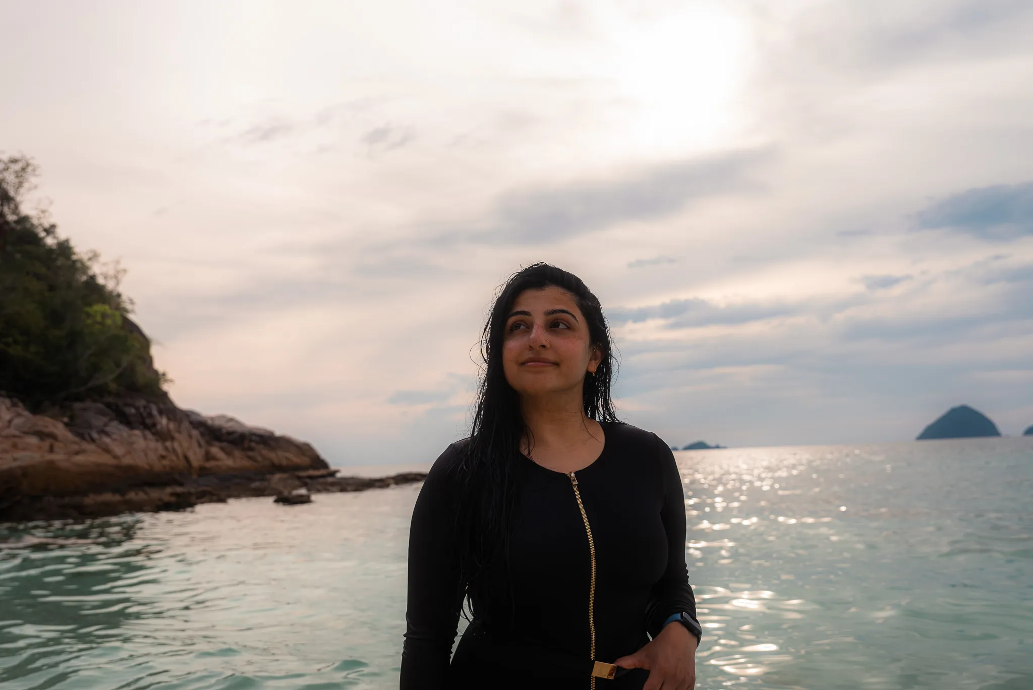 Aroob in the water at Romantic Beach, with a coastline and island in the distance.