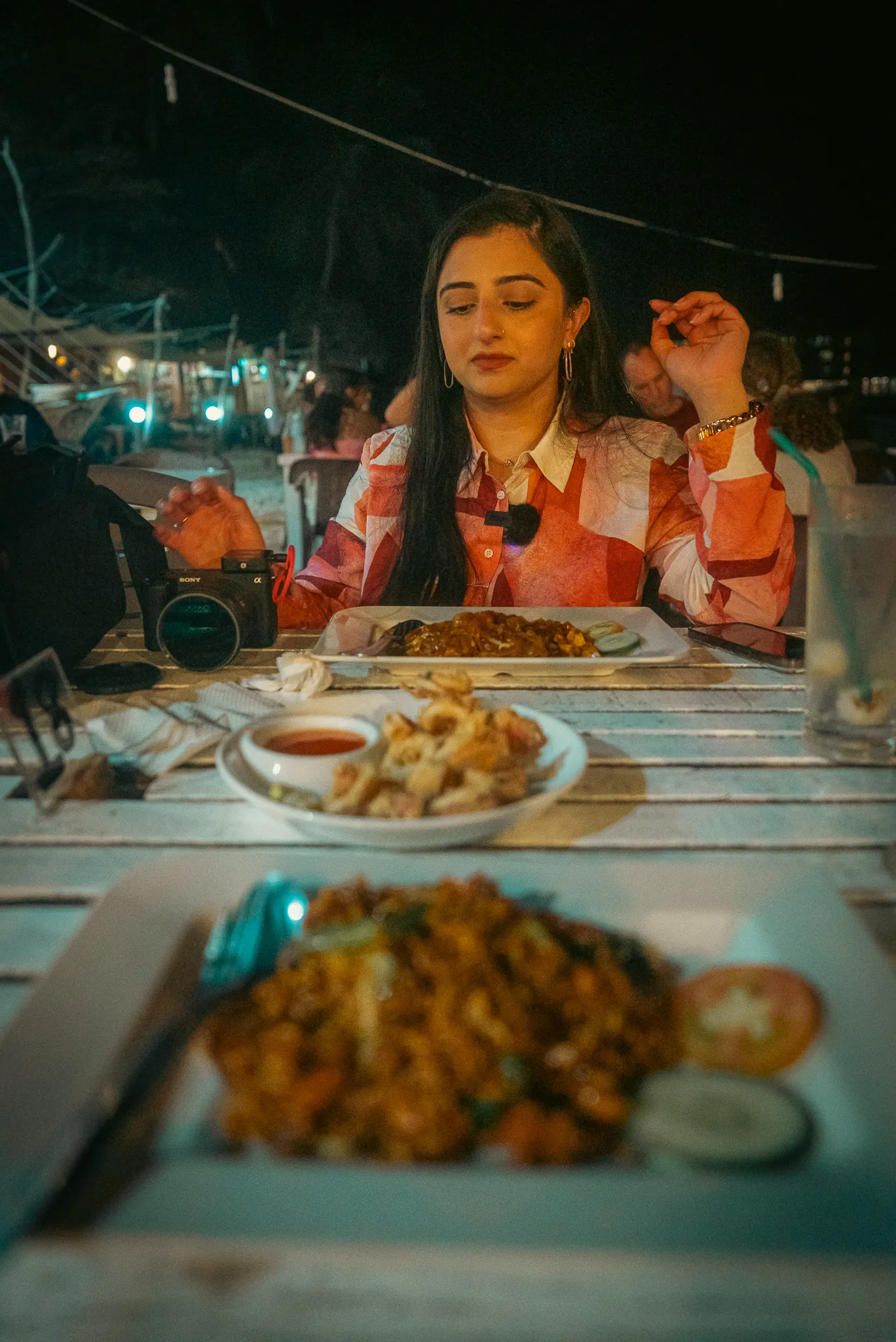 Aroob and I dining at Panorama Cafe on Long Beach at night, with plates of calamari, Maggi Goreng, and Char Kway Teow on the table.