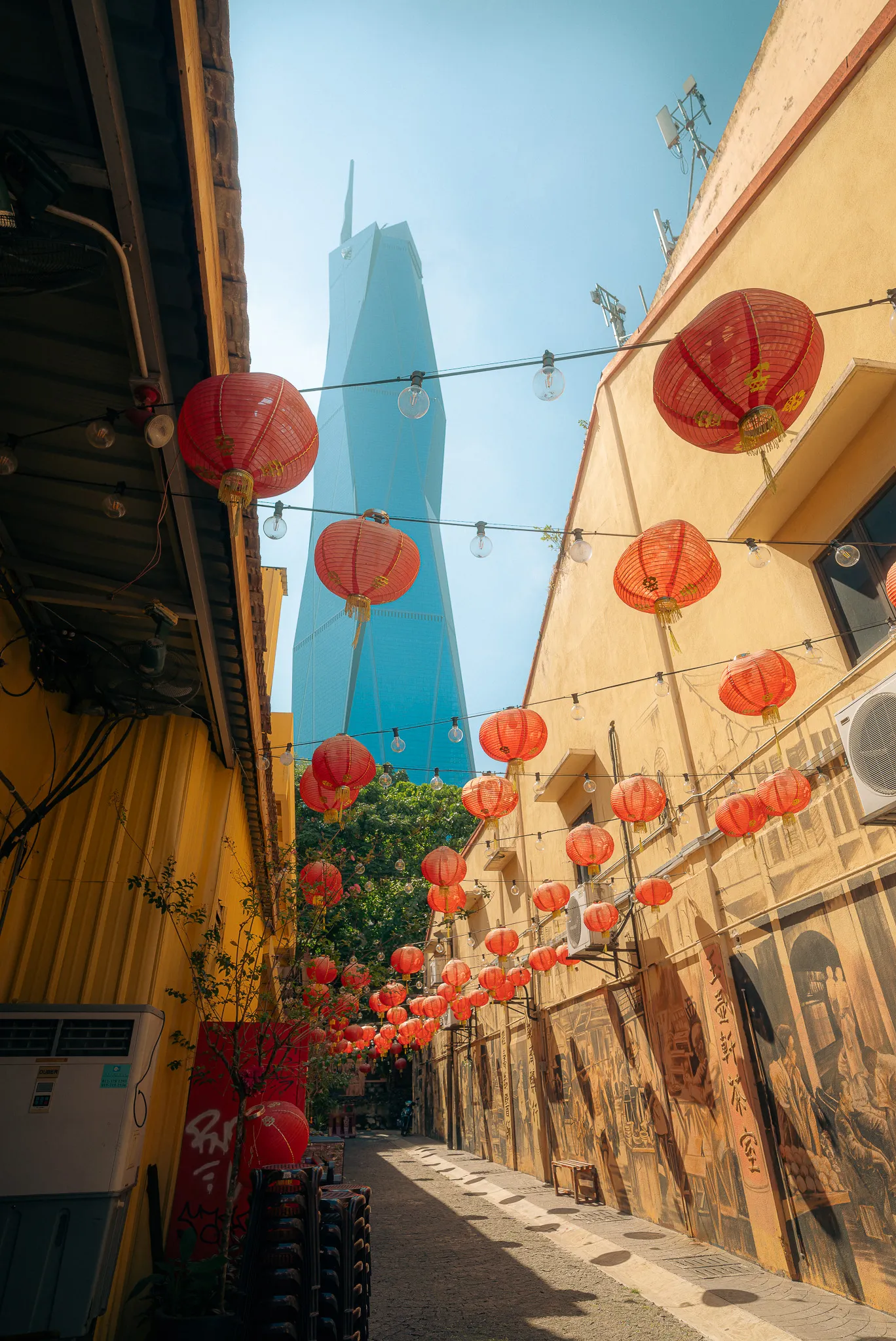 Chinatown alleyway, Kuala Lumpur, with red lanterns and view of Merdeka 118