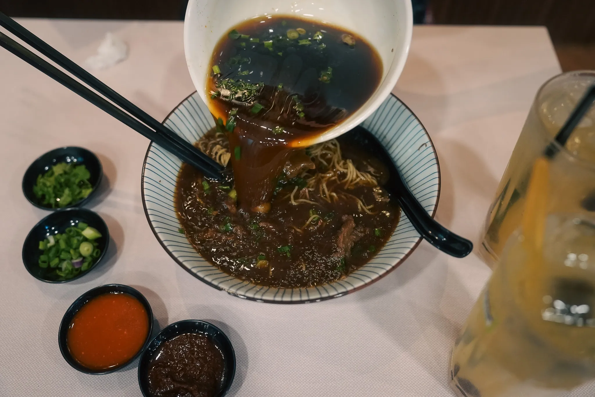 Adding extra broth to beef noodles at Kim Yong Gee Beef Noodle, Kuala Lumpur