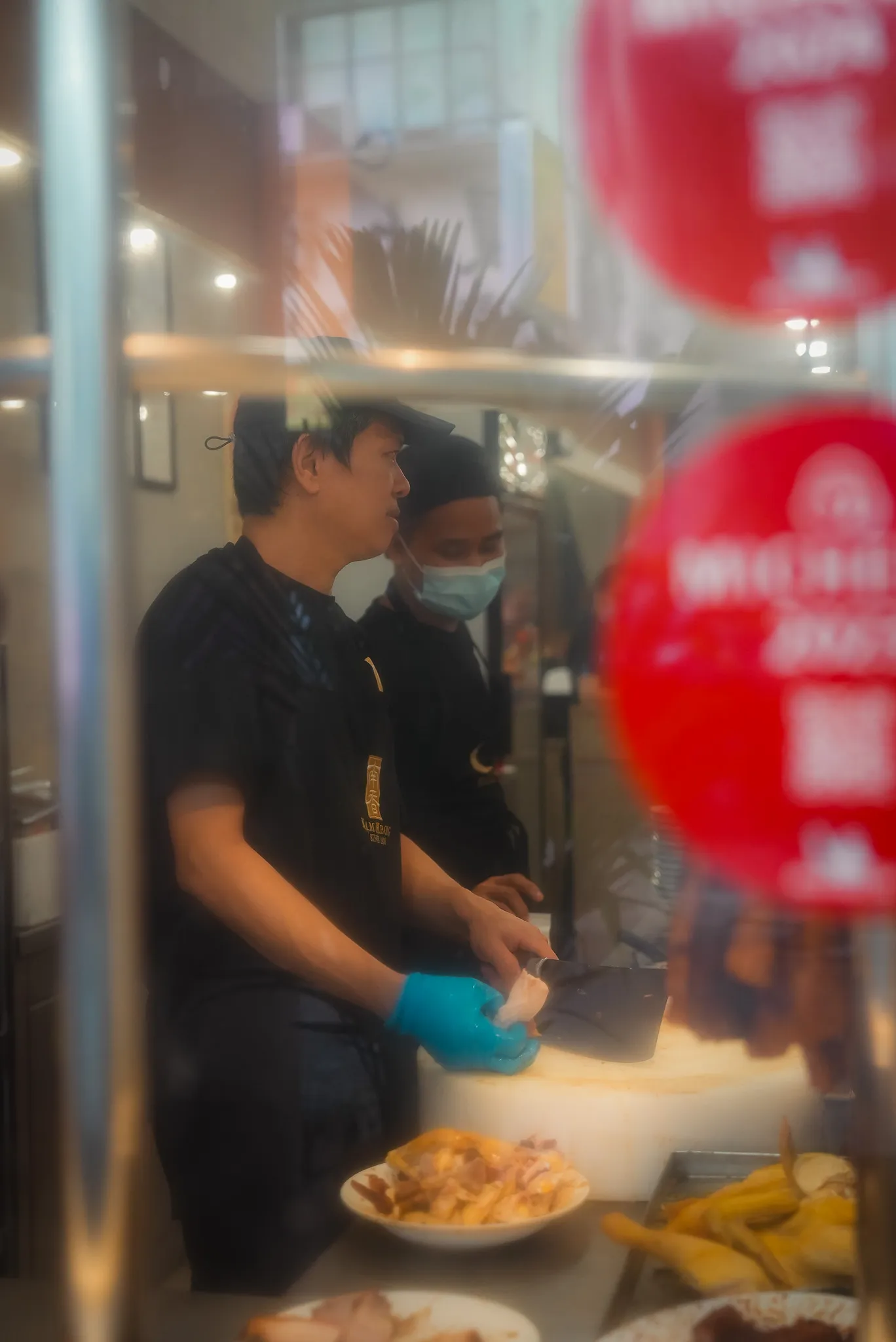 Workers preparing chicken at Nam Heong Chicken Rice, Kuala Lumpur